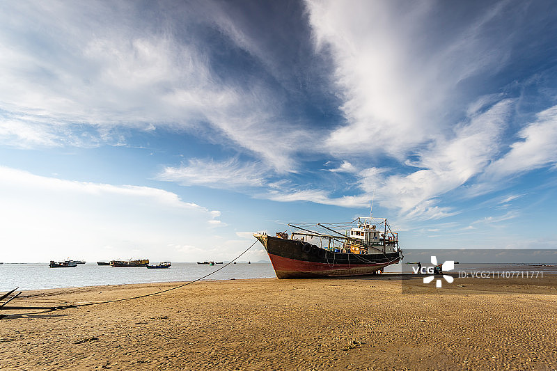 退潮后海滩上的渔船图片素材