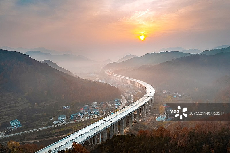 航拍朝阳下晨雾中蜿蜒伸展的即将竣工的栾卢高速路图片素材