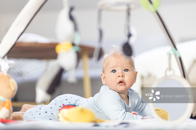 可爱的男婴在家玩悬挂玩具拱形垫图片素材