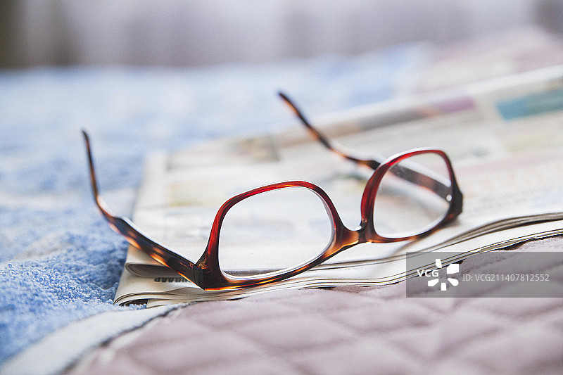 卧室报纸上的老式眼镜图片素材
