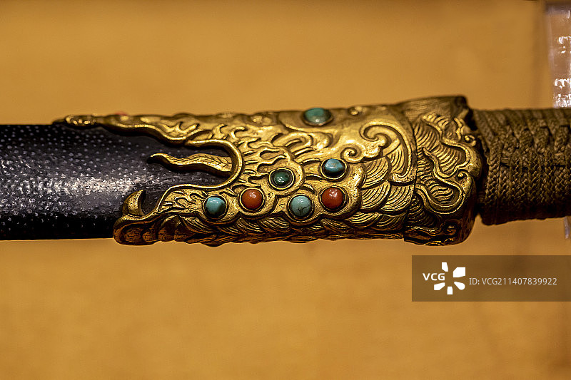 木嵌铜饰件柄鲨鱼皮鞘撩刃刀（清，钢质，柄木质，外缠黄绦带。铜叶形护手，柄头嵌铜质兽首，系黄丝带一根）图片素材