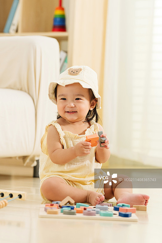 可爱的女宝宝坐在地上玩耍图片素材
