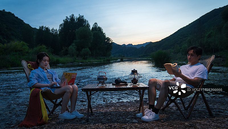 年轻伴侣夜晚在湖边露营图片素材