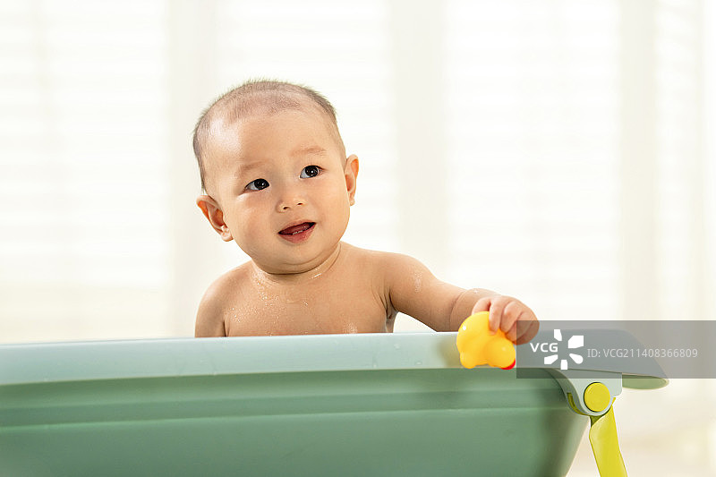 可爱宝宝坐在浴盆里洗澡图片素材