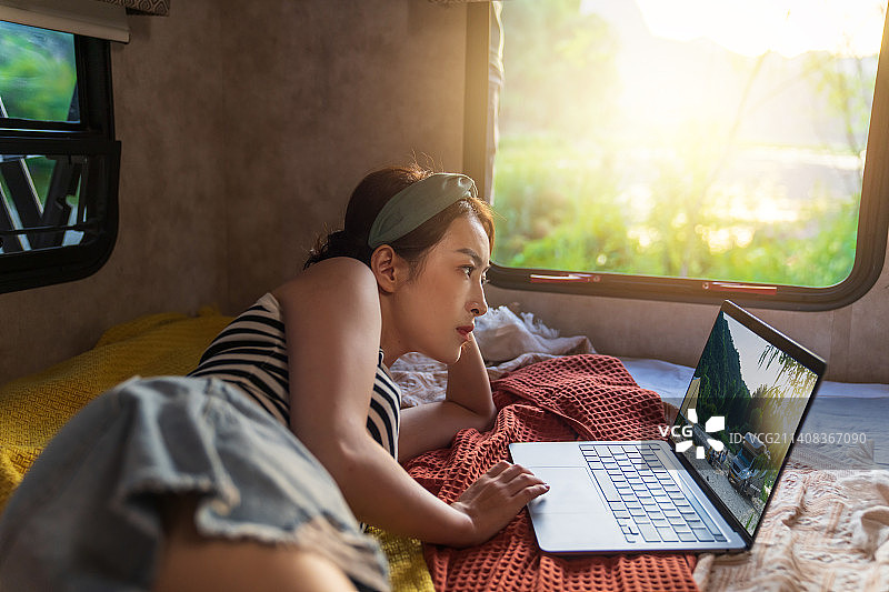 房车内的青年女人使用笔记本电脑图片素材