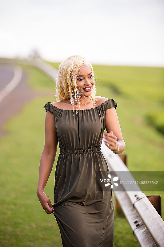 在肯尼亚内罗毕田野上微笑的年轻女子肖像图片素材