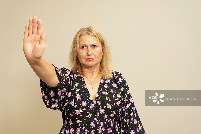 严肃的金发女人做出停止手势肖像图片素材