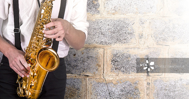 穿着白衬衫，拿着萨克斯的年轻人图片素材