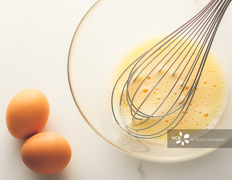 在白色大理石桌上搅拌鸡蛋，自制食品配方图片素材