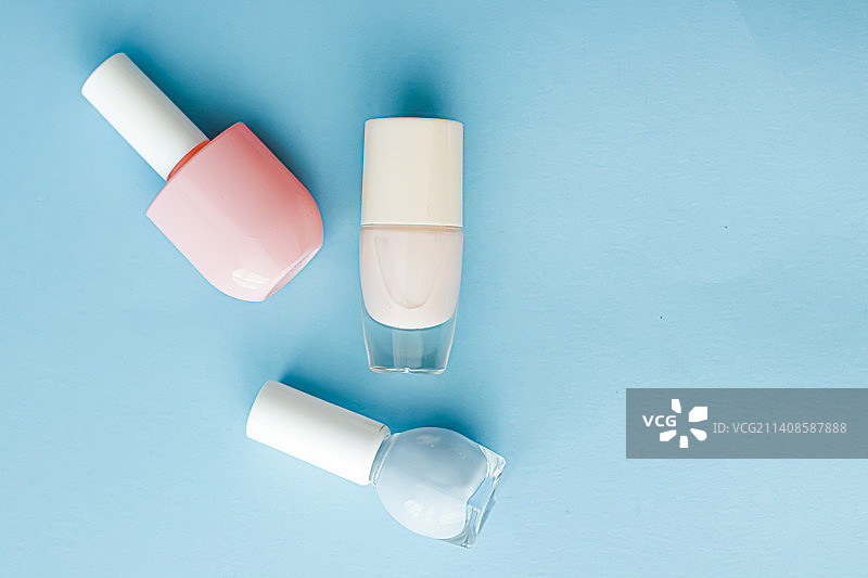 蓝色背景上的彩色指甲油瓶，有机化妆品图片素材