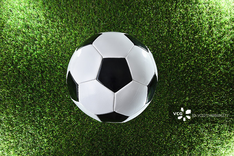 在四个聚光灯照射下的草地上，一个经典的足球图片素材