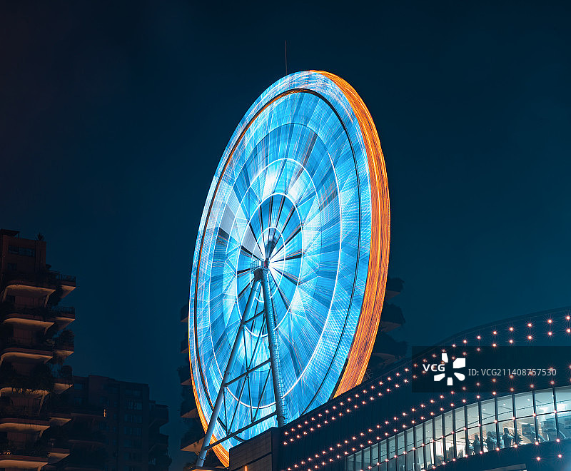 夜晚商场楼顶旋转的彩色摩天轮图片素材