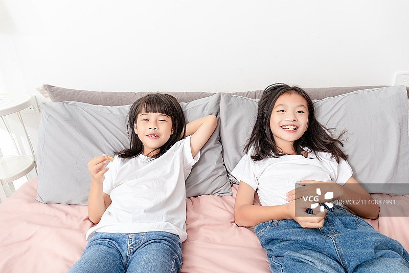 两个中国小女孩在家里吃糖果图片素材