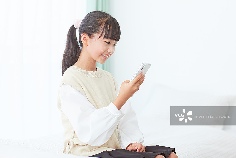 在家使用智能手机的日本儿童图片素材