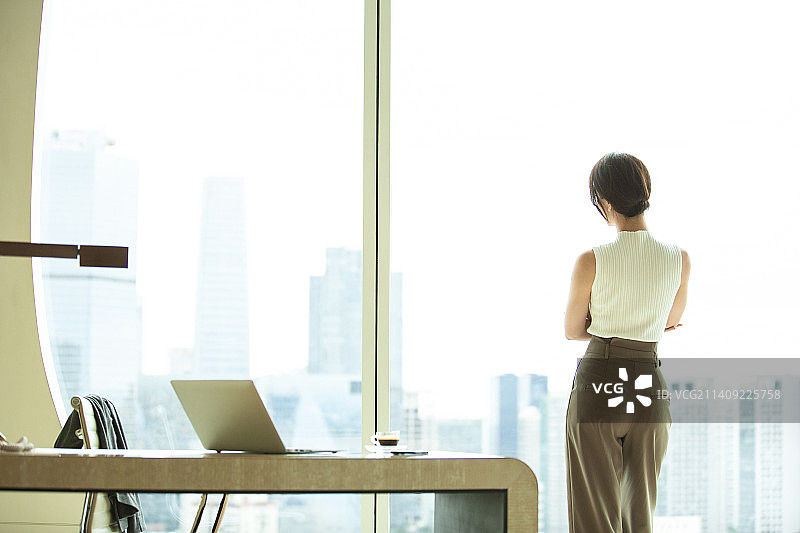 女商人站在酒店房间窗边看风景背影图片素材