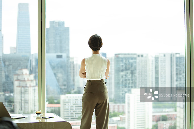商务女子站在酒店房间窗边看风景背影图片素材