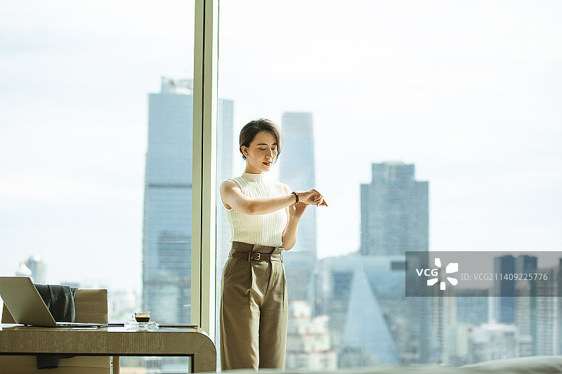 女商人在酒店房间看手表图片素材