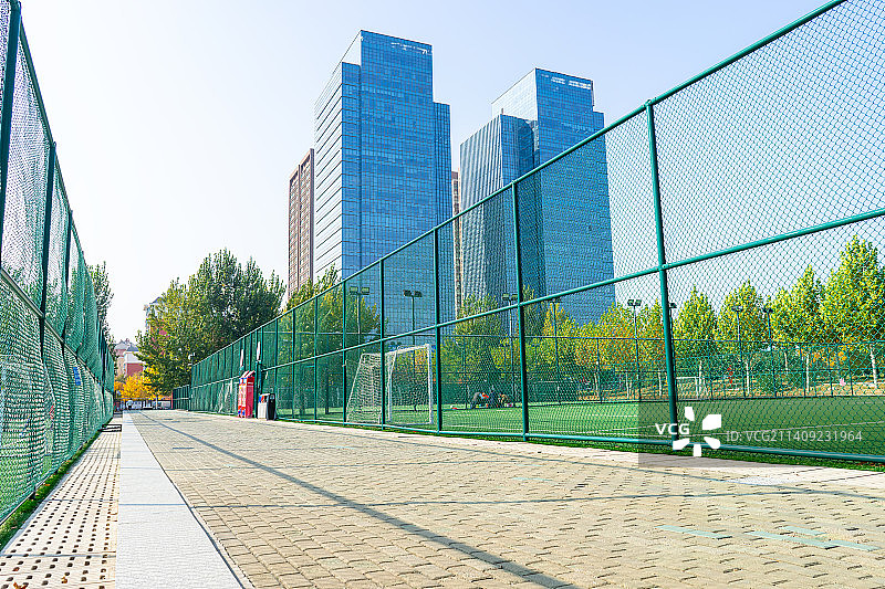 中国山东泰安泰安生态绿地健身活动公园的铺路石人行道和两侧的足球场铁丝网，户外白昼无人图像摄影图片素材