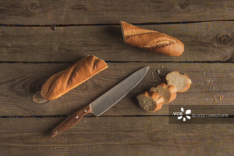 木桌上的面包和厨房刀具俯视图图片素材