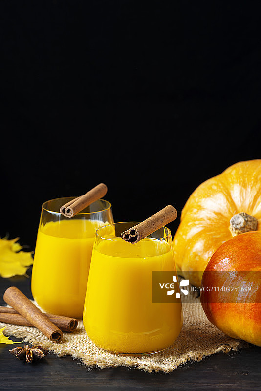 玻璃杯里的新鲜南瓜汁和橙色南瓜，健康美味食品概念图片素材