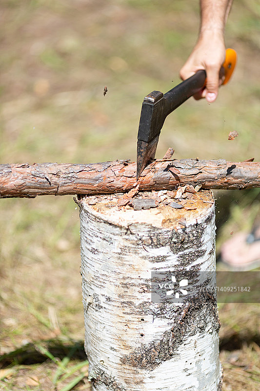 男子用斧头砍木头的特写，俄罗斯图片素材