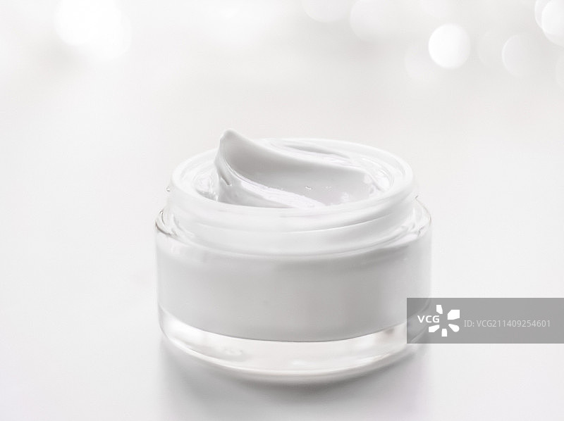 节日闪光背景下的面霜保湿罐，抗衰老图片素材