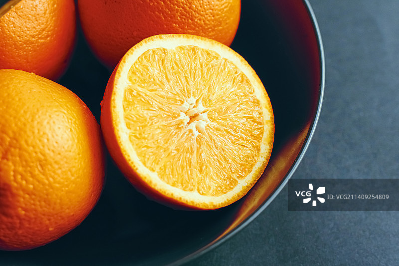黑色碗中新鲜多汁的橙子，健康饮食图片素材