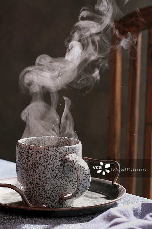 水壶倒茶入杯特写，蒸汽氤氲图片素材