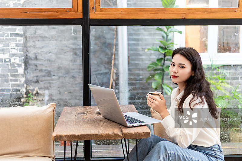 咖啡厅里使用手提电脑办公的中国美女图片素材