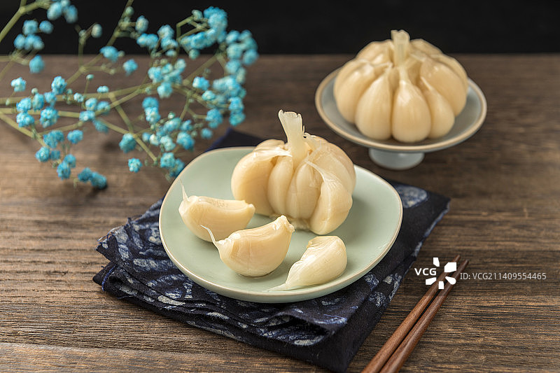 一盘糖蒜摆放在木桌面上特写图片素材