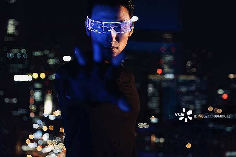 赛博朋克系列：未来男子戴着智能眼镜做伸手抓的手势图片素材