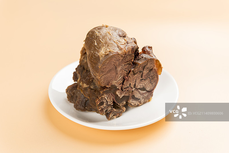 一盘酱牛肉摆放在暖色背景上特写图片素材