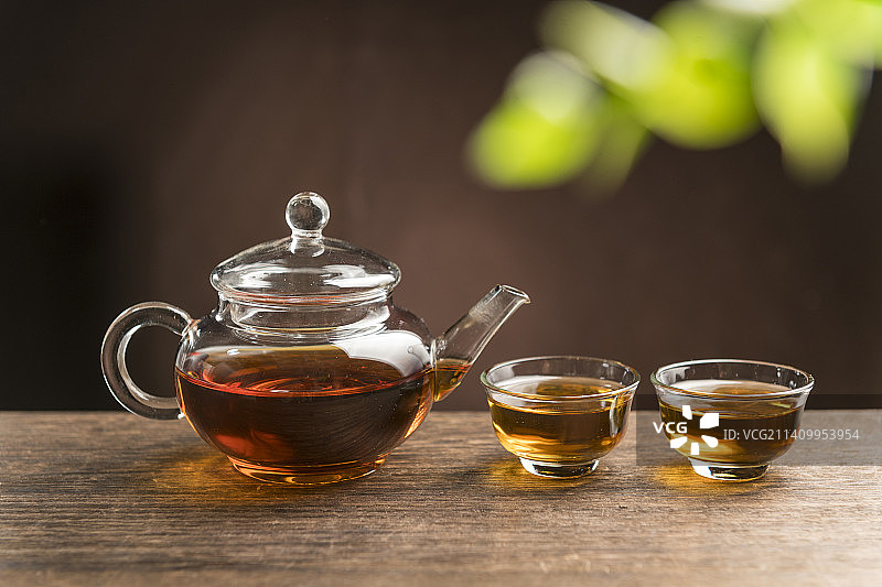 一壶普洱茶摆放在木桌面上特写图片素材