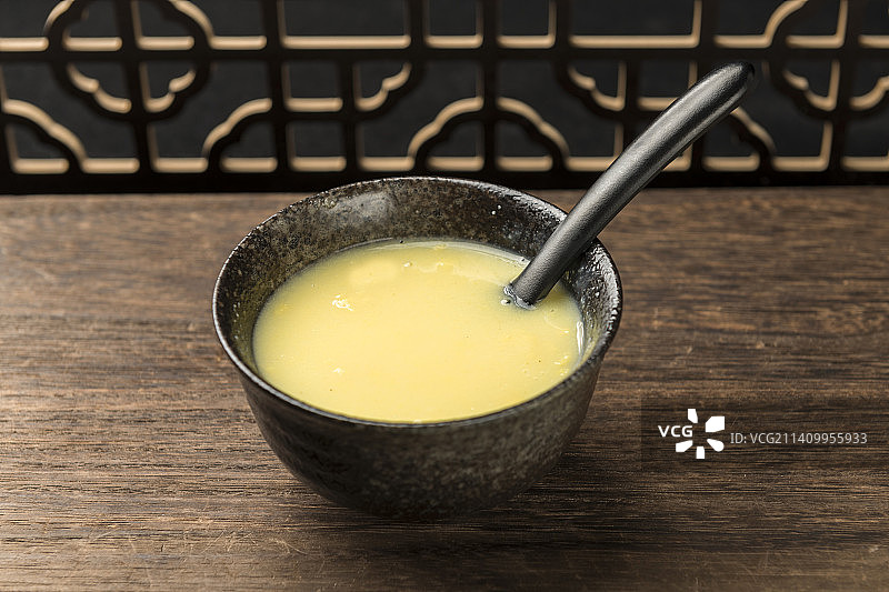 一碗玉米糊与玉米面玉米摆放在木桌面上特写图片素材