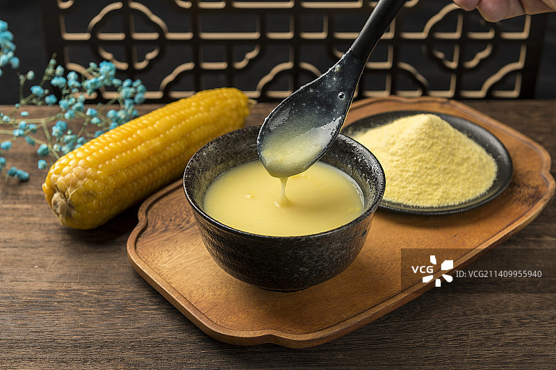 一碗玉米糊与玉米面玉米摆放在木桌面上特写图片素材