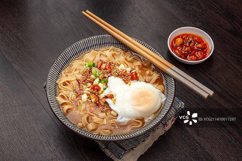 盛在传统兰花碗里的荷包蛋酸汤面图片素材