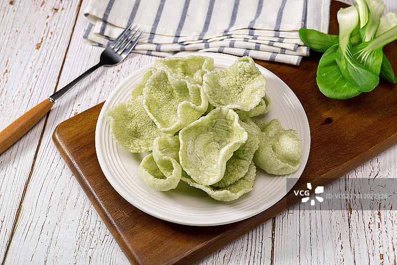 盘子里油炸菠菜味绿色虾片图片素材