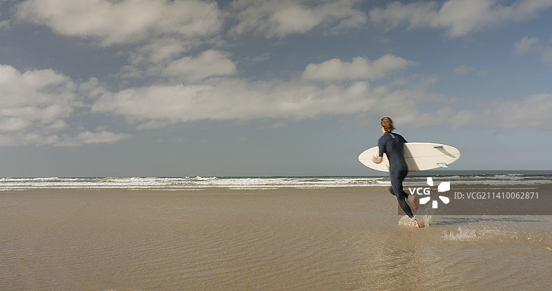 晴朗夏日冲浪者奔向浪头图片素材