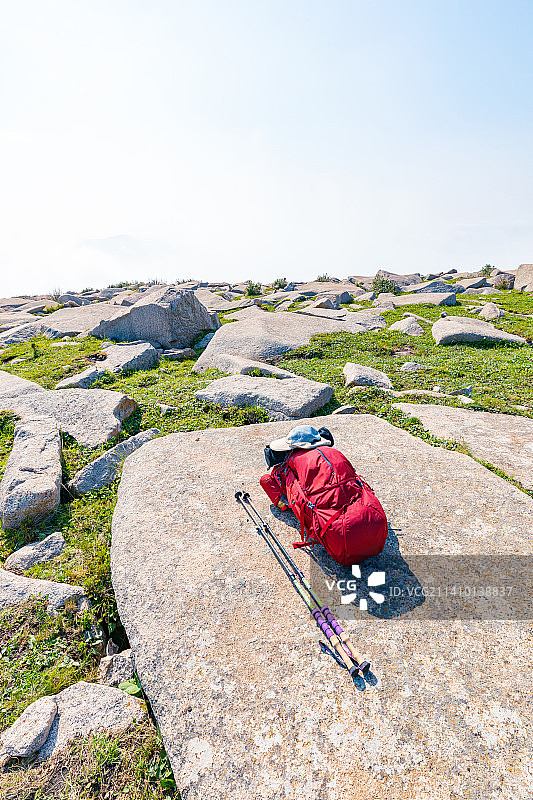 一个红色登山包放在大石头上图片素材