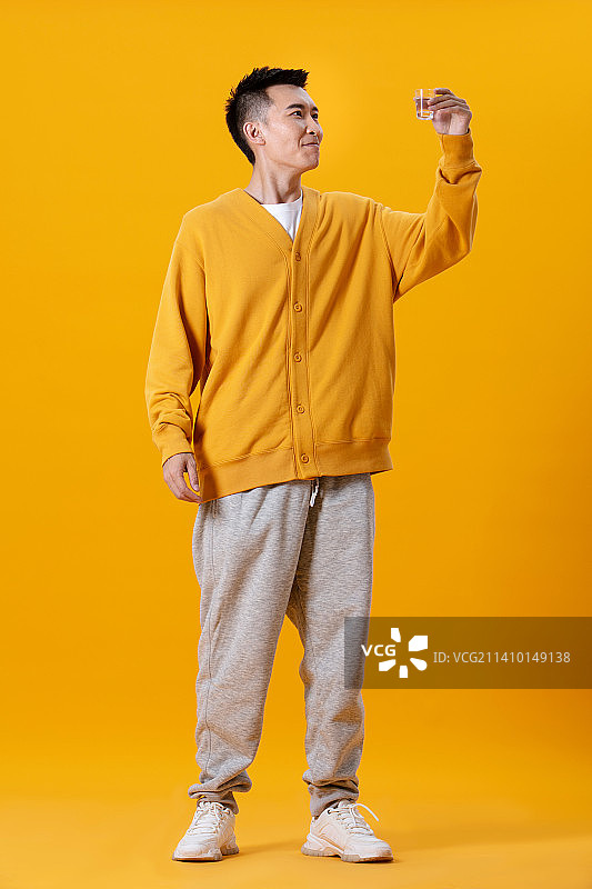 手拿玻璃杯的年轻男性图片素材