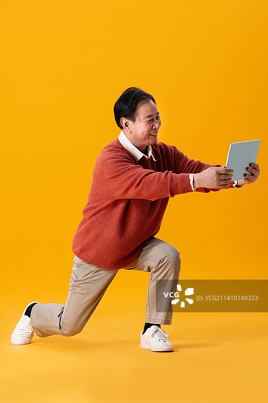 穿毛衣的老年人使用平板电脑图片素材