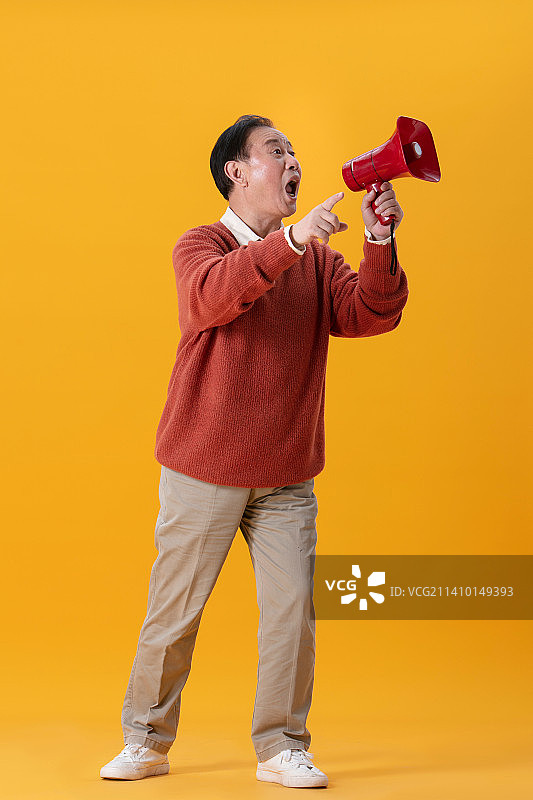 手拿红色喇叭的老年男人图片素材