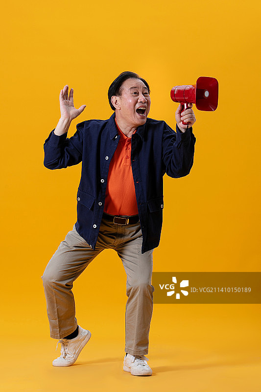 手持红色小喇叭的老年男性图片素材