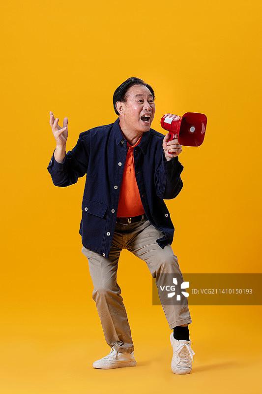 手持红色小喇叭的老年男性图片素材