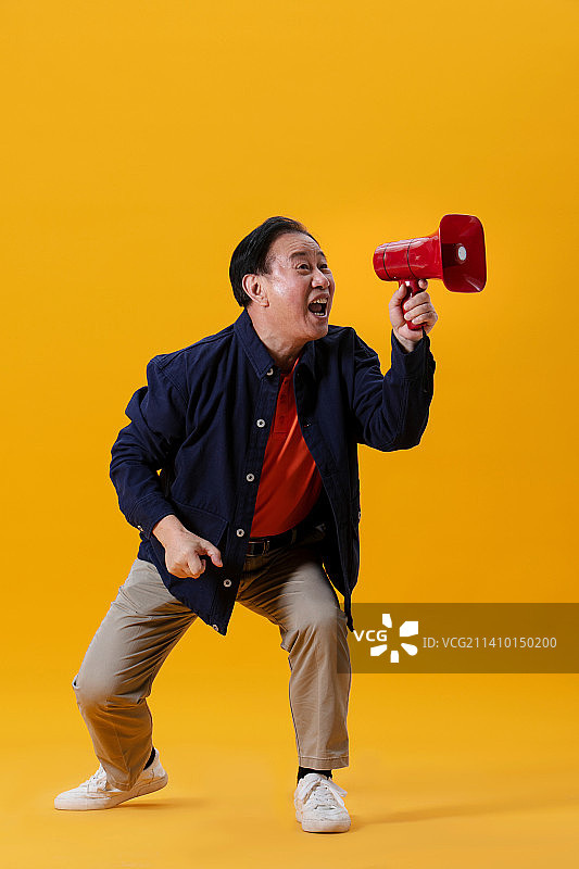手持红色小喇叭的老年男性图片素材
