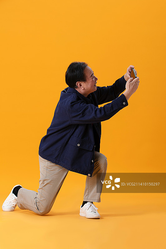 夸张地使用手机的老年男性图片素材