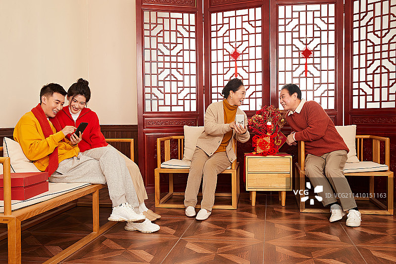 坐在沙发上的一家四口各自玩着手机图片素材