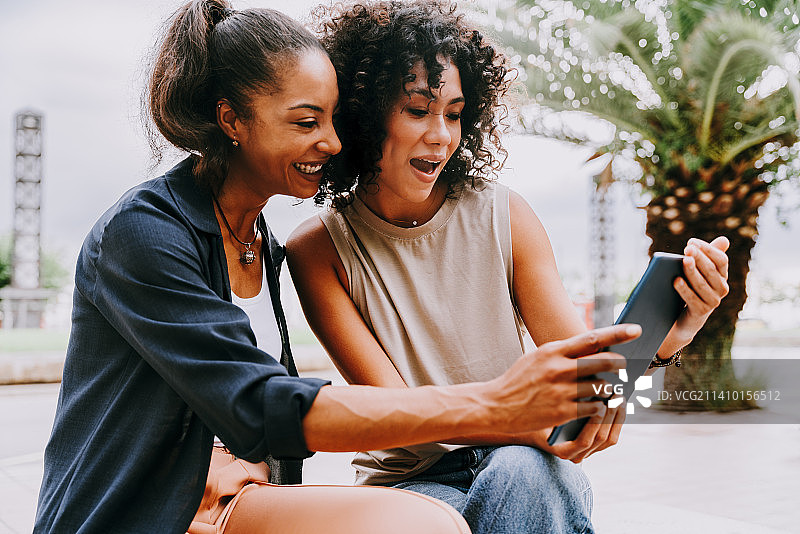 在西班牙巴塞罗那户外互动的两位混血西班牙裔女性图片素材
