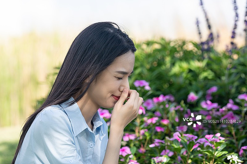 公园里一名年轻女性鼻子不舒服图片素材