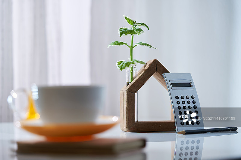 咖啡、计算器、记事本和带植物的房屋模型，马来西亚图片素材